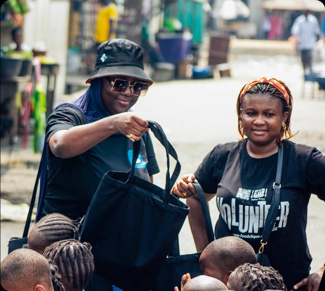a woman handing a bag to a child